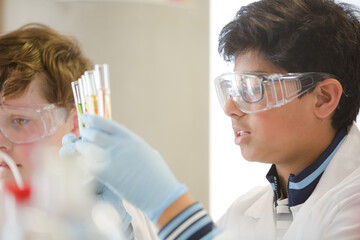 Boy students conducting scientific experiment in laboratory classroom