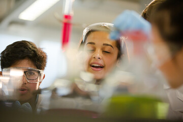 Students examining liquid in test tube, conducting scientific experiment in laboratory classroom