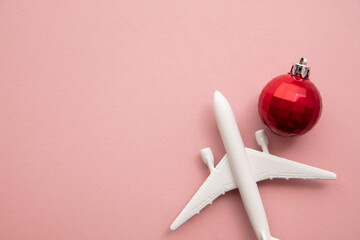 Christmas holiday travel background. Airplane with a red bauble decoration