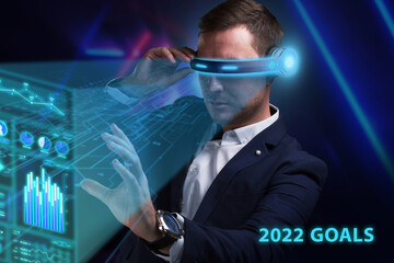Business, Technology, Internet and network concept. Young businessman working on a virtual screen of the future and sees the inscription: 2022 goals