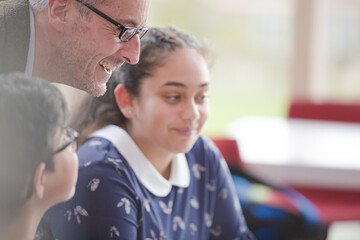 Male teacher and students using computer