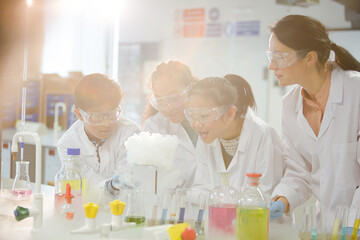 Surprised students conducting exploding foam scientific experiment in classroom laboratory