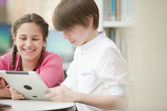 Students using digital tablet in library