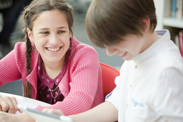 Students using digital tablet in library