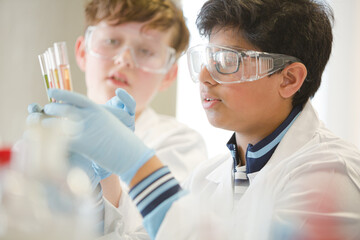 Boy students conducting scientific experiment in laboratory classroom