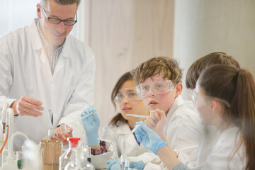 Male teacher and student conducting scientific experiment in laboratory classroom