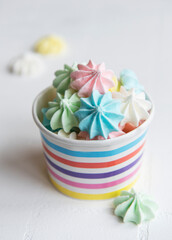 Small colorful meringues in the  paper bowl