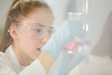 Fototapeta premium Girl students conducting science experiment in classroom laboratory