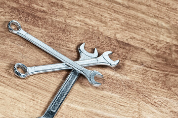 three wrenches iron one on top of the other on a wooden background