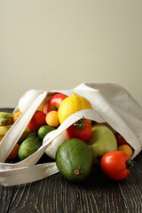 Cotton bag with vegetables and fruits on wooden table