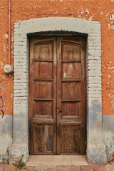 Antique wooden door facade with paint wear with copy space