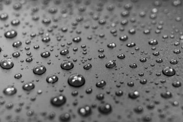 drops of water on a black background. texture. dew on the surface. moistening. drops after rain or fog. selective focus