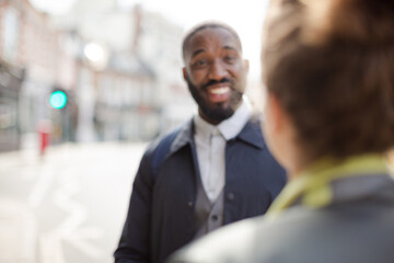 Smiling businessman with bicycle and woman on urban street