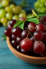 Bowl with red grape and green grape on wooden background