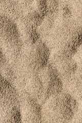 Wallpaper, texture of a beach of sea sand in the form of dunes. Summer, vacation and sea concept.