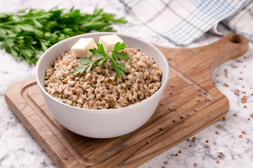 Freshly cooked buckwheat porridge in a plate on a gray background.