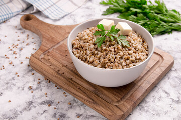 Freshly cooked buckwheat porridge in a plate on a gray background.