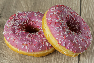 Tasty glazed raspberry donut with topping.