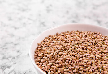 Uncooked organic buckwheat grains in bowl