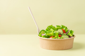 Healthy vegetable salad in recyclable cardboard container. Food delivery, healthy food menu for...