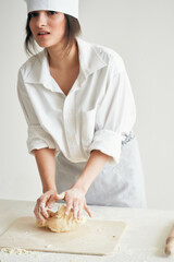 woman in chef's uniform flour products rolling dough homework