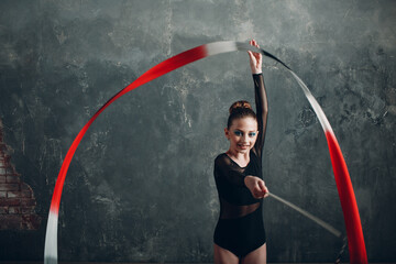 Young girl professional gymnast woman dance rhythmic gymnastics with ribbon round at studio.