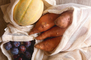 Reusable mesh bag filled with fresh fruit and vegetables. Top view.