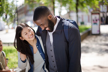 Portrait smiling, affectionate young couple hugging in sunny park