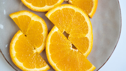 Perfectly sliced oranges on a gray plate. Half rings of oranges on plate. Saturated oranges are sliced on a plate