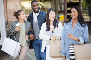 Smiling friends with coffee and shopping bags