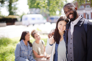 Portrait smiling, affectionate young couple hugging in sunny park