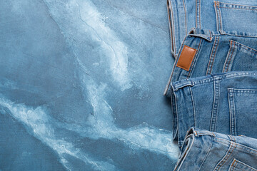Different types of jeans. Jeans of different colors on a blue background. Jeans texture.