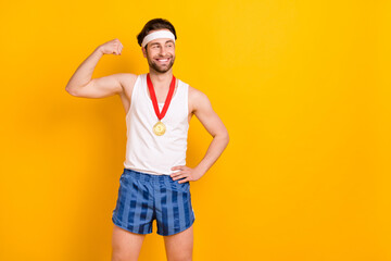 Fototapeta na wymiar Portrait of attractive cheerful content guy leader demonstrating muscles copy space isolated over bright yellow color background