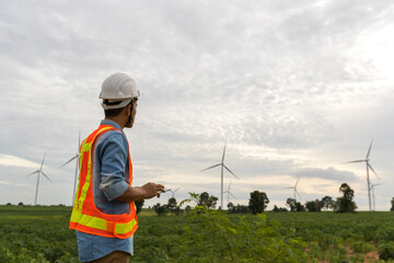 Picture of asian male electrical engineer working at wind turbine power generator station