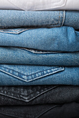 A stack of different types of jeans. Jeans of different colors. Jeans texture.