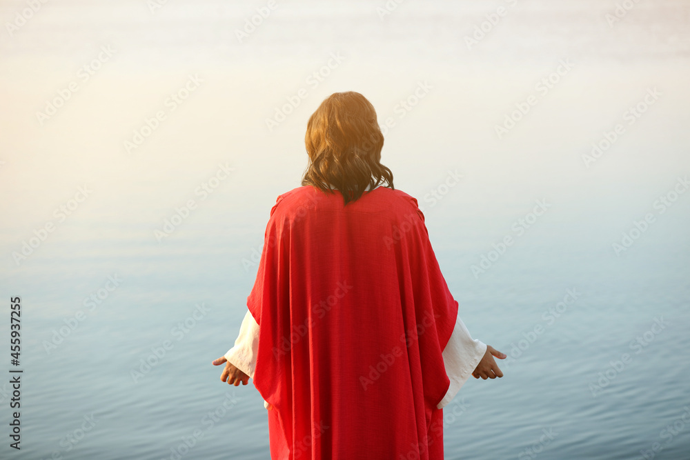 Wall mural jesus christ near water outdoors, back view