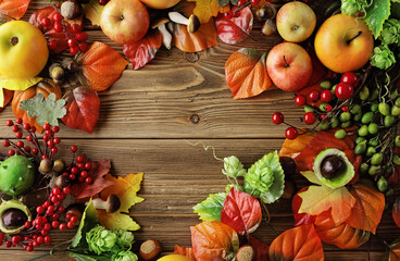 Naklejka na ściany i meble colorful leaves, acorns, nuts, apples and mushrooms on wooden background