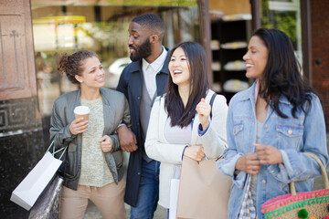 Smiling friends with coffee and shopping bags