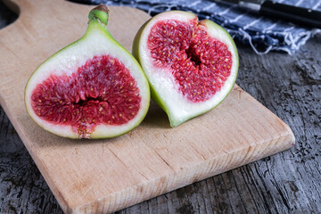 A green fig cut in half on rustic background