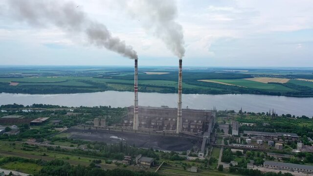 Aerial view of big factory territory with huge tubes. Industrial architecture factory warehouses.