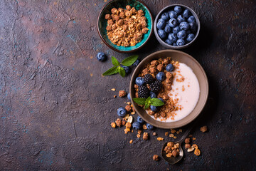 Bowl of healthy breakfast with granola, yogurt, fresh berries and mint