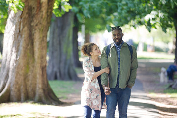 Young couple holding hands, walking in park