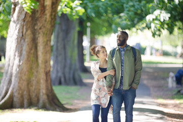 Fototapeta premium Young couple holding hands, walking in park