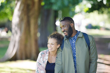 Young couple holding hands, walking in park