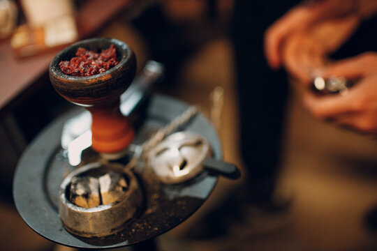 Shisha hookah tobacco putting in bowl for smoking and leisure