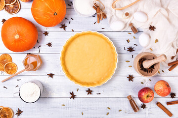 Homemade spicy pumpkin pie with cinnamon and pecan nuts and bottle of red wine on wooden rustic...