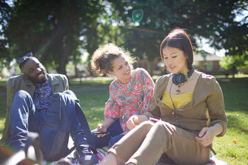 Young friends relaxing in sunny summer park