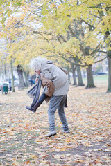 Fototapeta premium Senior man carrying woman on his back in autumn park