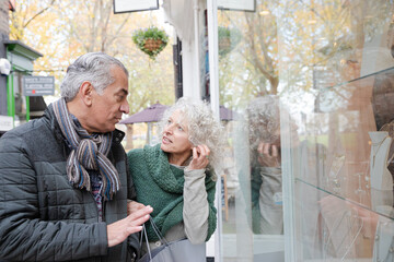 Senior couple window shopping at storefront