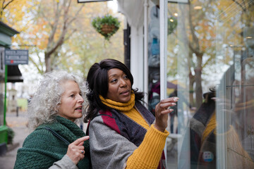 Senior women friends window shopping outside storefront